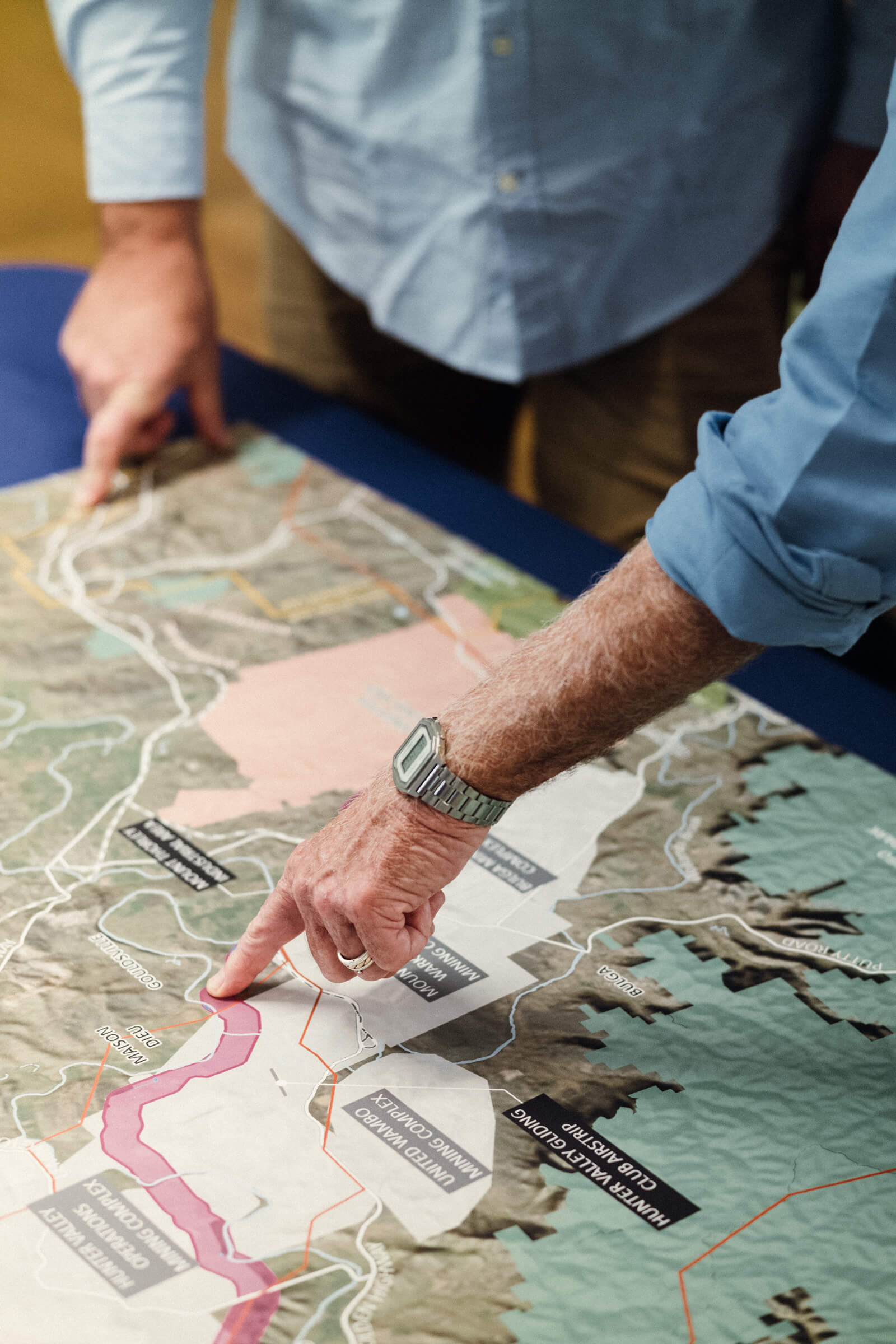 Two people point at a map of the Hunter Transmission Project.